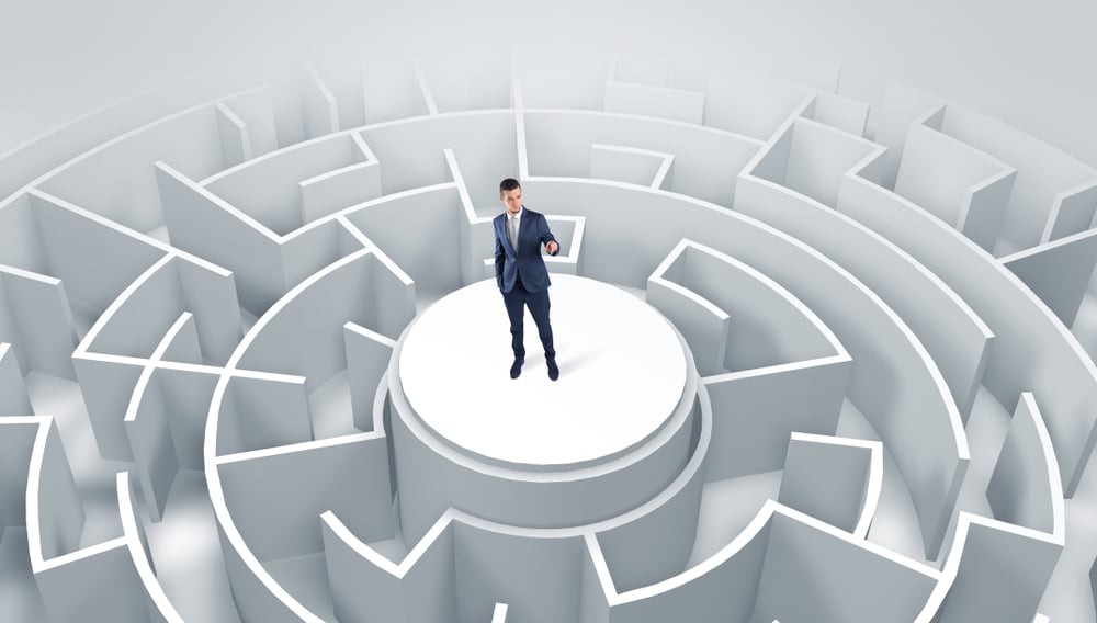 Businessman standing on the top a maze and looking through Businessman standing on the top a maze and looking through